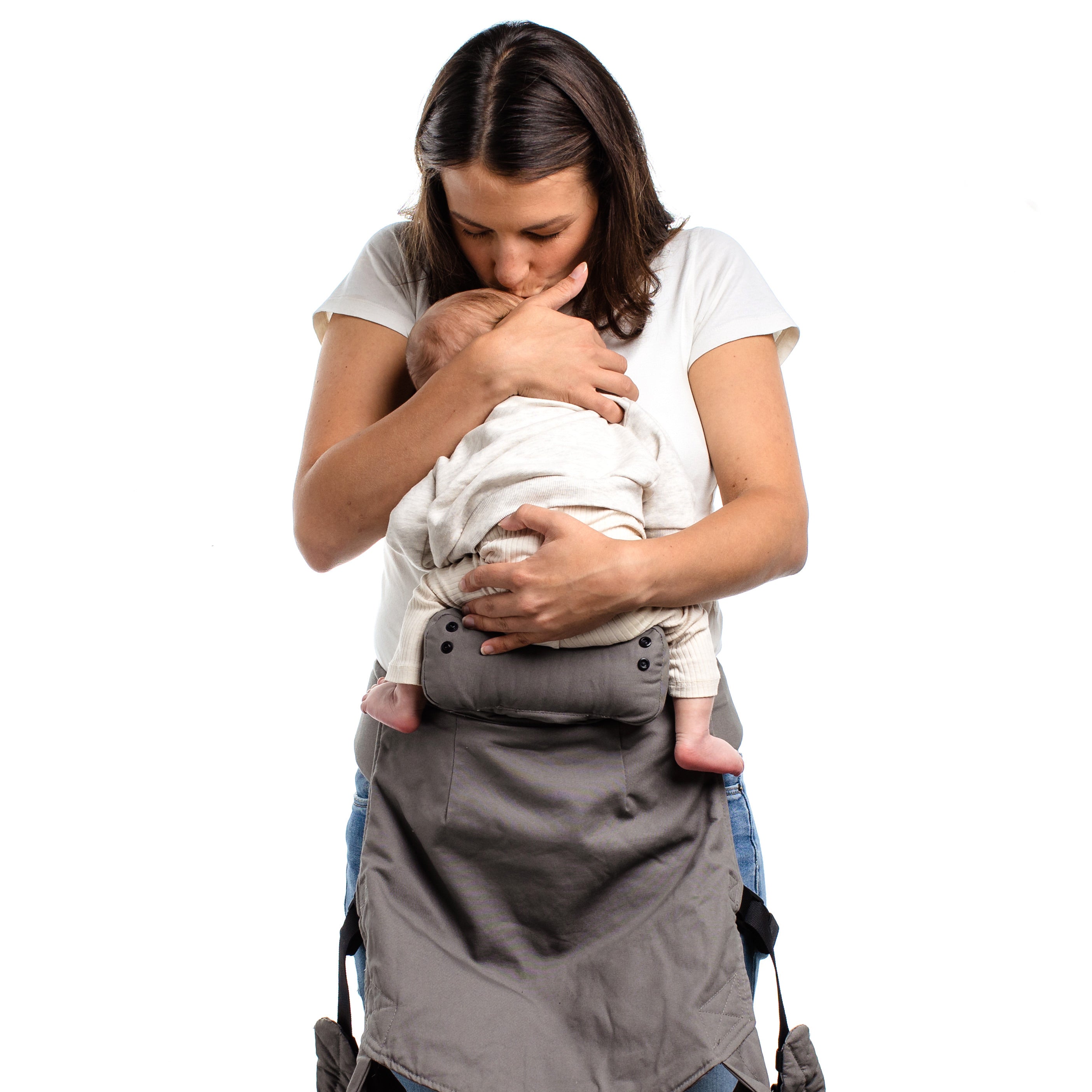 Brown haired mom is holding her baby on her front kissing his sleeping face as she is about to put him in a front carry ergonomic position in the boba 4gs classic carrier using the infant insert.