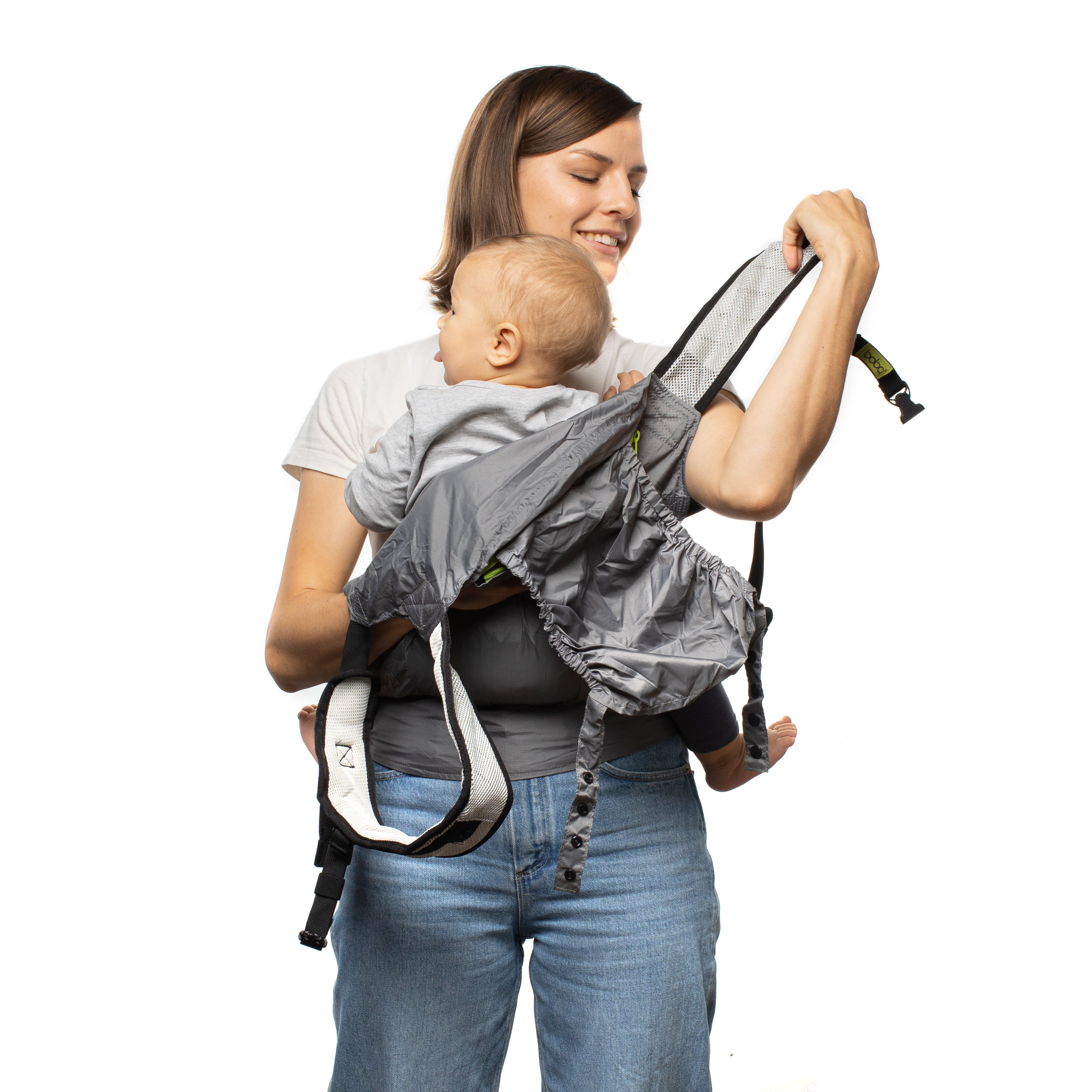 Mom putting her baby in a front carry position in the gray Boba Air baby carrier.