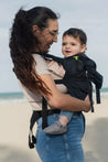 A lightweight, Boba Air Baby Travel Carrier with padded mesh straps, leg openings, adjustable shoulder straps, and an integrated hood. Compact and self-storing, it fits babies 4-24 months (15+ lbs) and children up to 45 lbs,  Black