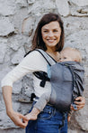 A lightweight, Boba Air Baby Travel Carrier with padded mesh straps, leg openings, adjustable shoulder straps, and an integrated hood. Compact and self-storing, it fits babies 4-24 months (15+ lbs) and children up to 45 lbs, Gray