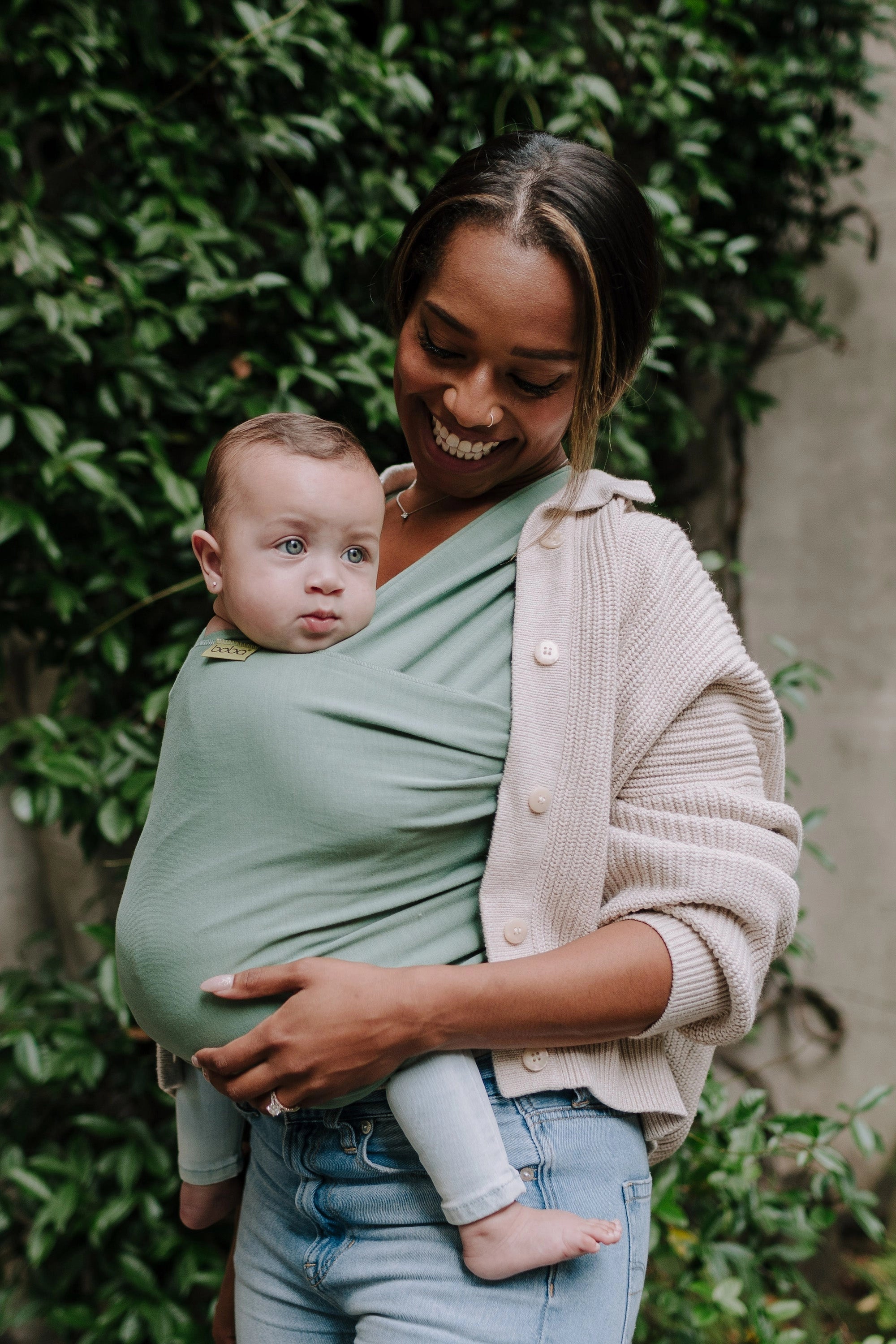 A Boba Classic Baby Wrap, made from a soft 95% French Terry cotton blend and 5% Spandex. Ergonomic, award-winning design fits babies from 7 Ibs to 35 Ibs, best up to 20 Ibs. Machine washable, dryer friendly, and certified hip-healthy. Sage Green