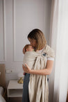 A Boba Ring Sling Baby Carrier made from a unique linen bamboo viscose fabric blend, perfect for all seasons. Lightweight and breathable, it stores compactly, ideal for newborn snuggles to toddler ups and downs (8 - 35Ibs). Pampas Beige