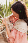 A Boba Ring Sling Baby Carrier made from a unique linen bamboo viscose fabric blend, perfect for all seasons. Lightweight and breathable, it stores compactly, ideal for newborn snuggles to toddler ups and downs (8 - 35Ibs). Pampas Beige