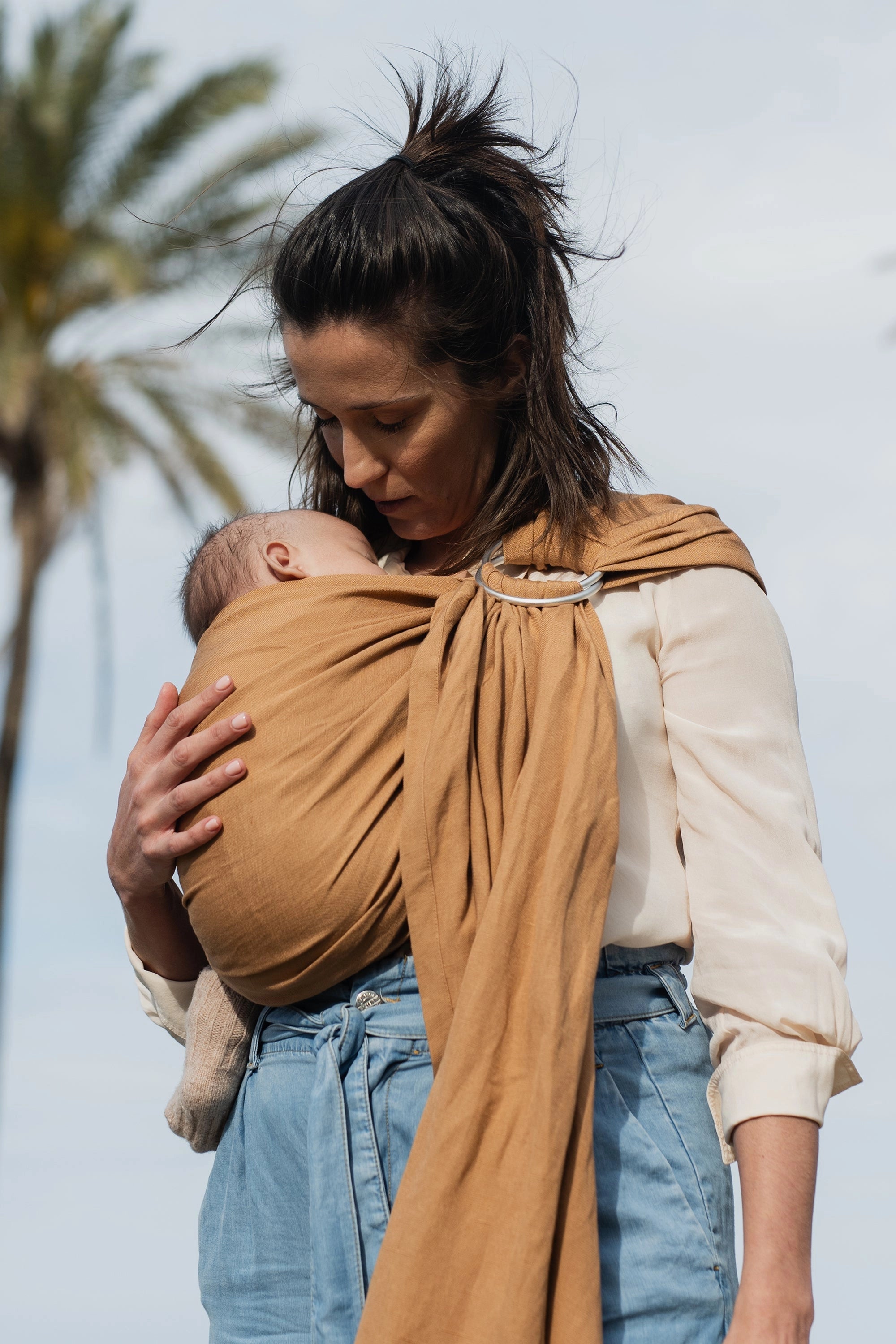 A Boba Ring Sling Baby Carrier made from a unique linen bamboo viscose fabric blend, perfect for all seasons. Lightweight and breathable, it stores compactly, ideal for newborn snuggles to toddler ups and downs (8 - 35Ibs). Rye Brown