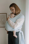 A Boba Serenity Baby Wrap, made from a buttery soft, extra breathable bamboo blend fabric (68% Viscose from Bamboo, 25% Cotton, 7% Spandex). Ergonomic, award-winning design fits babies from 7 Ibs to 35 Ibs, best up to 20 Ibs. Machine washable, dryer friendly, and certified hip-healthy. Light Blue