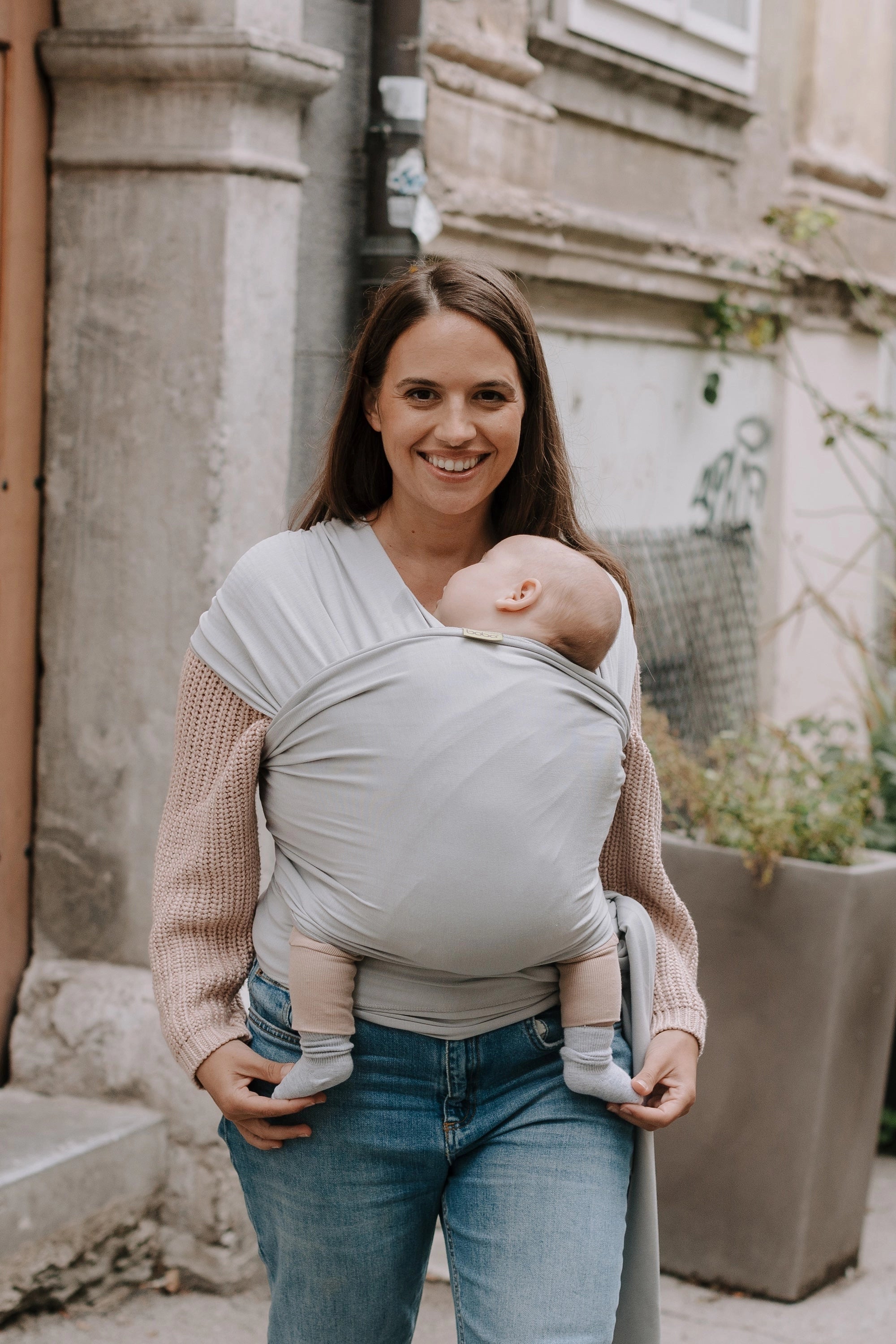 A Boba Serenity Baby Wrap, made from a buttery soft, extra breathable bamboo blend fabric (68% Viscose from Bamboo, 25% Cotton, 7% Spandex). Ergonomic, award-winning design fits babies from 7 Ibs to 35 Ibs, best up to 20 Ibs. Machine washable, dryer friendly, and certified hip-healthy. Light Gray