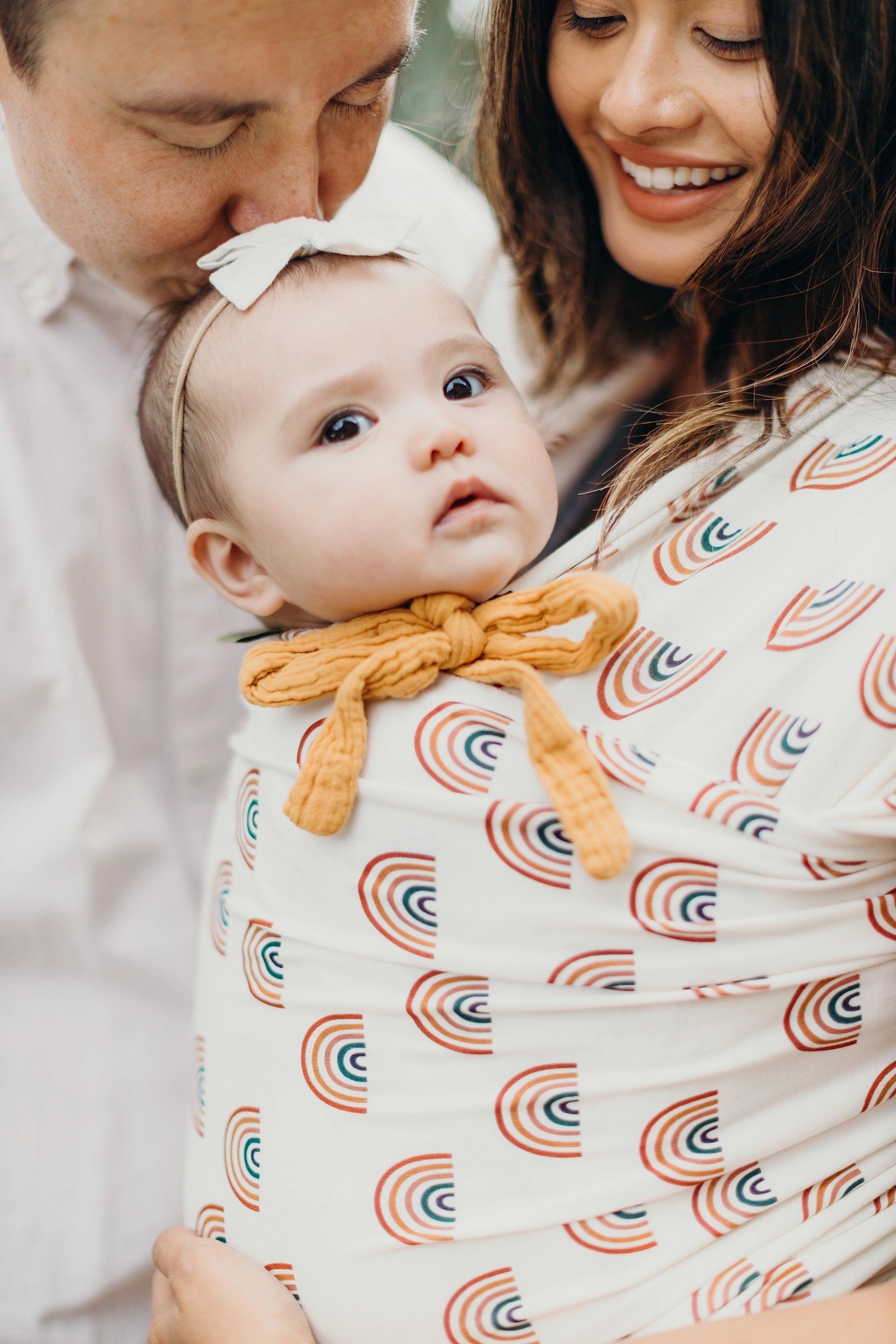 A Boba Serenity Baby Wrap, made from a buttery soft, extra breathable bamboo blend fabric (68% Viscose from Bamboo, 25% Cotton, 7% Spandex). Ergonomic, award-winning design fits babies from 7 Ibs to 35 Ibs, best up to 20 Ibs. Machine washable, dryer friendly, and certified hip-healthy. Rainbows