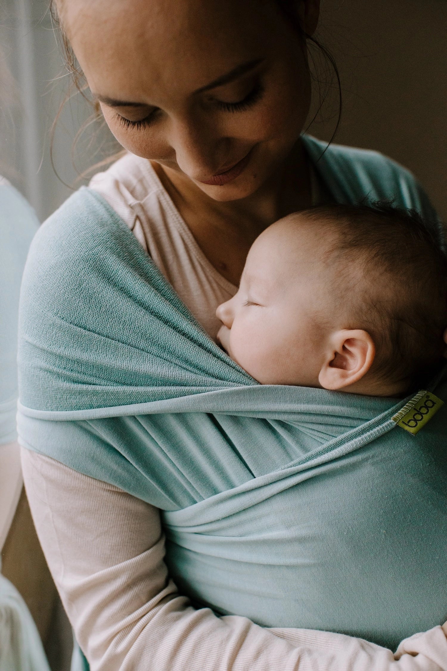 A Boba Serenity Baby Wrap, made from a buttery soft, extra breathable bamboo blend fabric (68% Viscose from Bamboo, 25% Cotton, 7% Spandex). Ergonomic, award-winning design fits babies from 7 Ibs to 35 Ibs, best up to 20 Ibs. Machine washable, dryer friendly, and certified hip-healthy. Sea Mist