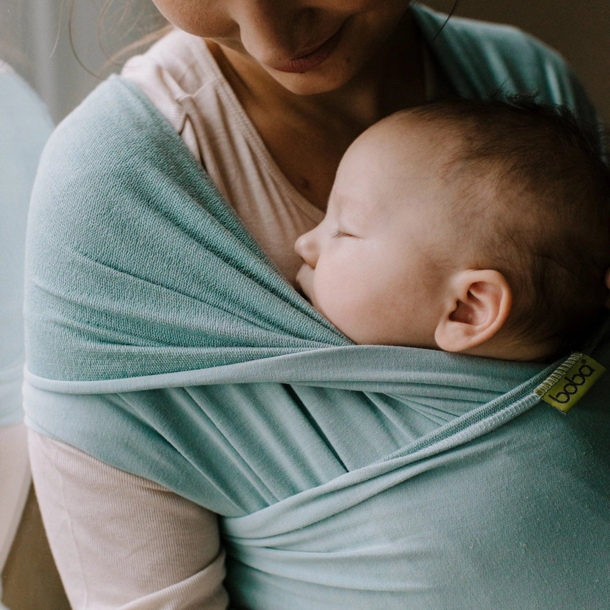 A Boba Serenity Baby Wrap, made from a buttery soft, extra breathable bamboo blend fabric (68% Viscose from Bamboo, 25% Cotton, 7% Spandex). Ergonomic, award-winning design fits babies from 7 Ibs to 35 Ibs, best up to 20 Ibs. Machine washable, dryer friendly, and certified hip-healthy. Sea Mist