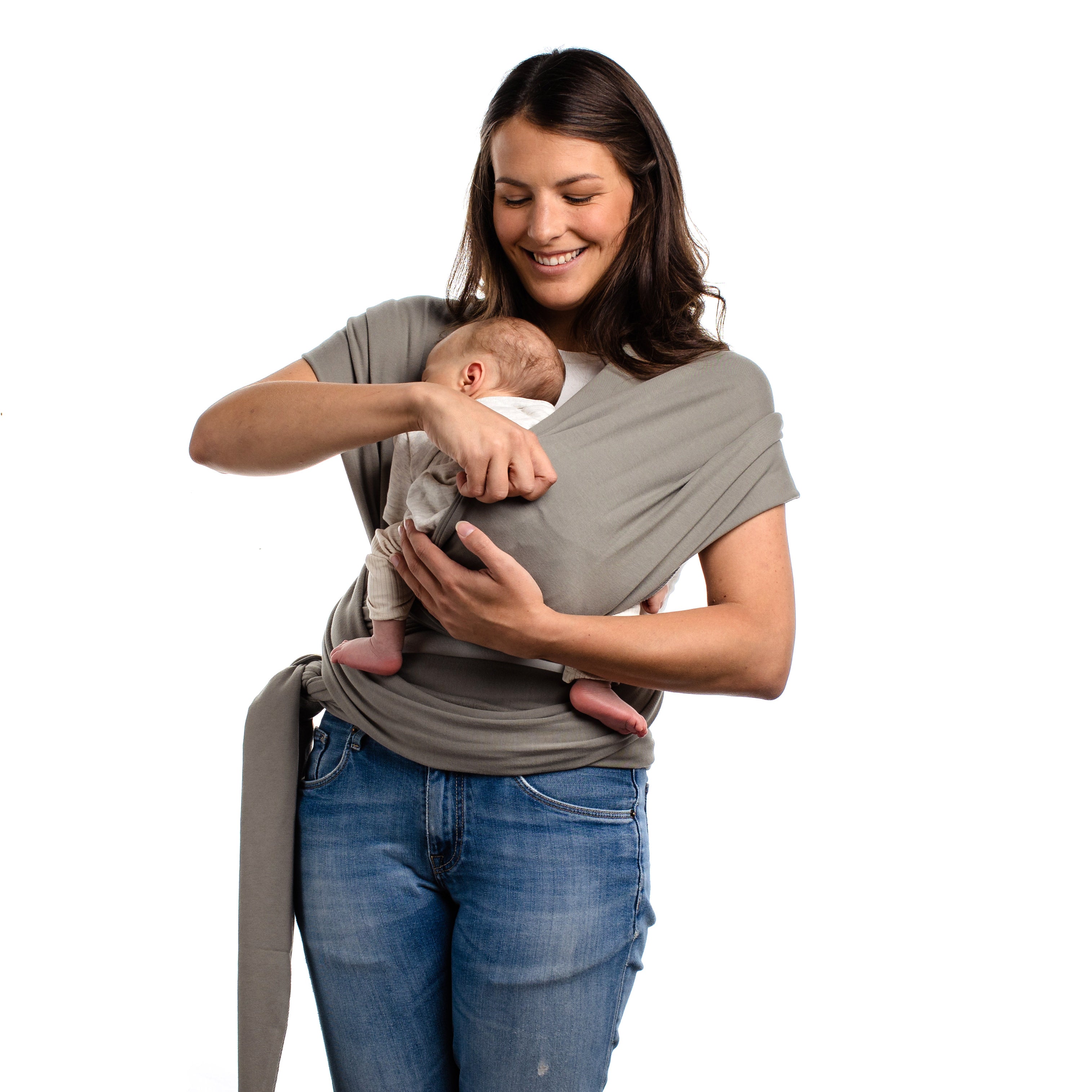 Happy young smiling mom with a newborn baby. She is putting her son in the front carry position in the gray Boba Wrap.